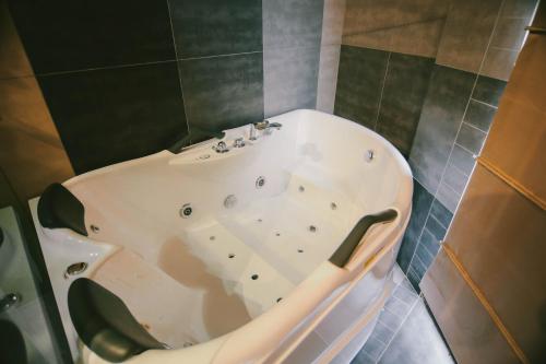 a bath tub with a sink in a bathroom at Savaneti Eco Hotel in Tʼelavi