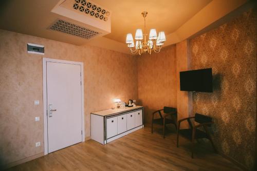a room with a table and chairs and a television at Savaneti Eco Hotel in Tʼelavi