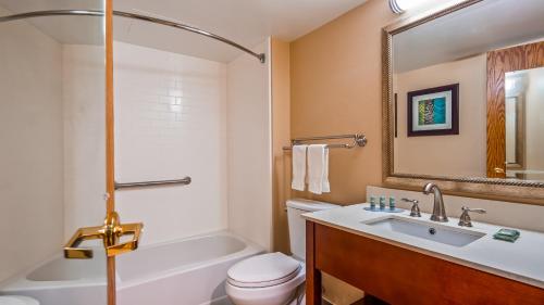 a bathroom with a sink and a toilet and a bath tub at Best Western Warren Hotel in Warren