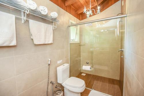 a bathroom with a toilet and a shower at Hotel Kehl Haus in Gramado