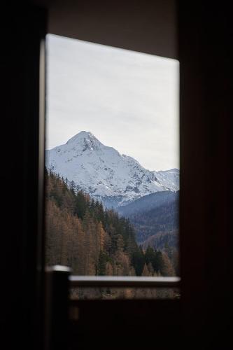 a view of a snow covered mountain through a window at Hotel Garni Schönblick in Sölden