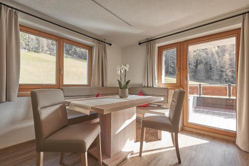 a dining room with a table and chairs and windows at Hotel Garni Schönblick in Sölden