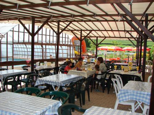 a group of people sitting at tables in a restaurant at Camping Moulin de Collonge in Saint-Boil