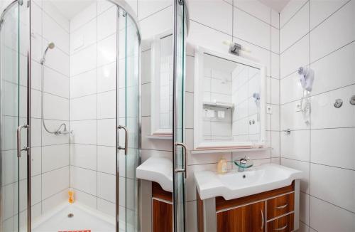 a bathroom with a shower and a sink and a mirror at Ark Beach Apartments in Split