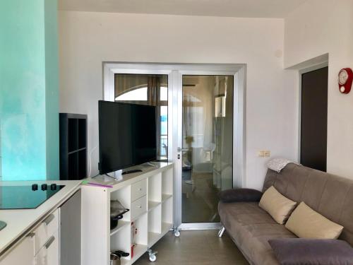 a living room with a couch and a flat screen tv at LOFT-Beach-apartments RATKO in Novi Vinodolski