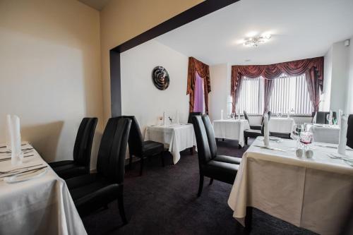a dining room with two tables and chairs with white table cloth at Seaview Hotel in Peterhead