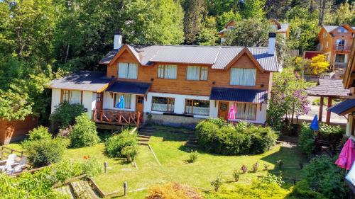 a large wooden house with a yard at Cabañas Temporada in San Martín de los Andes