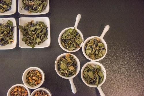 a group of bowls of vegetables with spoons on a table at Dining & Living Alpenrose in Bressanone