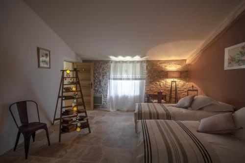 La Ressence Luberon في بونيو: غرفة نوم مع سريرين ورف مع زجاجات النبيذ