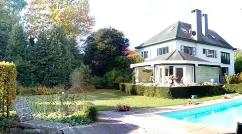 a house with a swimming pool in front of it at La Pastorale Brussels Expo in Wemmel