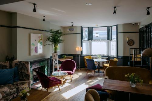 a living room with chairs and a fireplace at The Rose in Deal