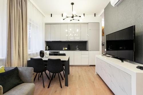 eine Küche und ein Wohnzimmer mit einem Tisch und Stühlen in der Unterkunft Luxury for everyone - Hills Park Lux Apartments 2 in Vilnius