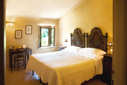 Schlafzimmer mit einem Bett, einem Schreibtisch und einem Fenster in der Unterkunft La Tavola Dei Cavalieri in Assisi