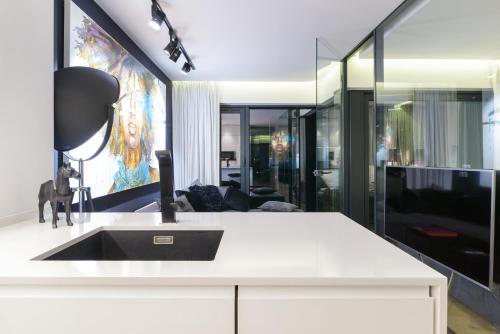 a kitchen with a sink and a living room at Andersia Park in Poznań