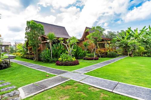 a house with a green lawn and a house at Bali Natha Beach Front in Canggu