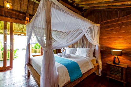 een slaapkamer met een hemelbed bij Bali Natha Beach Front in Canggu