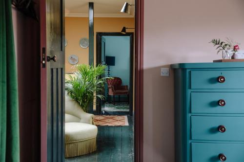 a hallway with a blue dresser and a mirror at The Rose in Deal