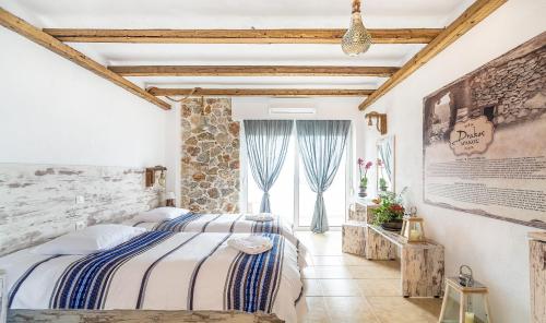 a bedroom with two beds and a stone wall at Limeri Traditional Guest House in Monólithos