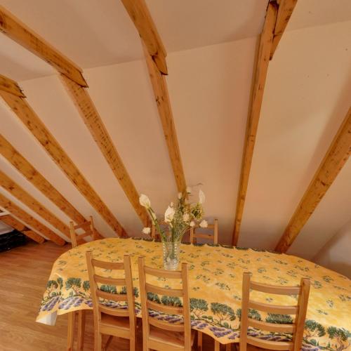 a dining room table with chairs and a vase of flowers at Chalet Pointu in Isola 2000