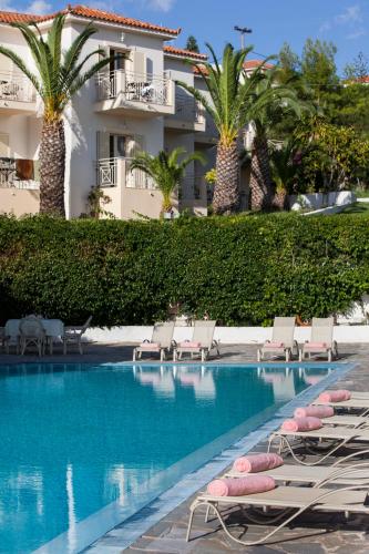 a resort swimming pool with lounge chairs and palm trees at Princess Hotel in Lassi