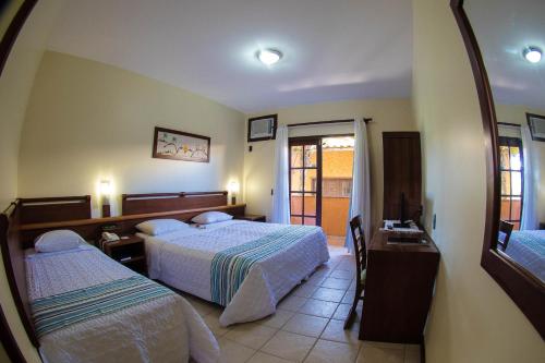 Habitación de hotel con 2 camas y espejo en Hotel Laguna Blu, en Aquiraz