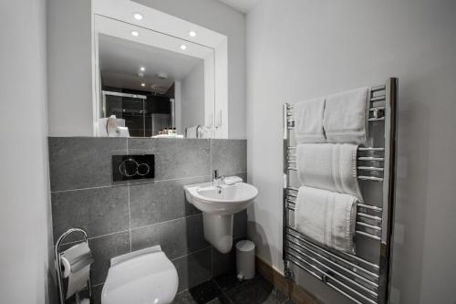 a bathroom with a sink and a toilet and a mirror at Seaview Hotel in Peterhead