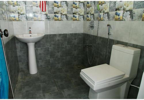 a bathroom with a toilet and a sink at Marari Adonis Beach Villa in Mararikulam