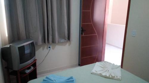 a television sitting on a table next to a mirror at Hospedaria Casa da Lia in Mucugê