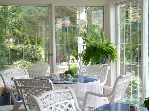 a porch with a table and chairs and windows at Lakeside Country Inn in Savona
