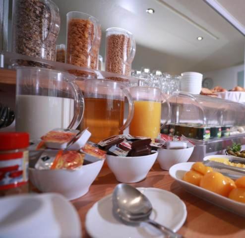 a table with plates of food and glasses of orange juice at Hotel Savoy Bonn in Bonn