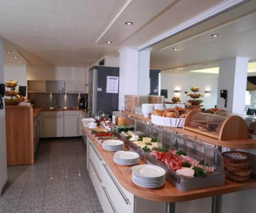 a buffet line in a restaurant with food on it at Hotel Savoy Bonn in Bonn