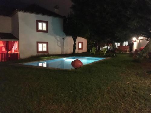 a swimming pool in the yard of a house at night at Lisbon Cozy House w/Garden and Pool in Valejas