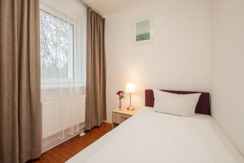 a bedroom with a white bed and a window at Hotel City Green Berlin in Berlin