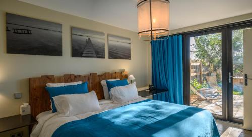 a bedroom with a bed with blue sheets and a window at Domaine Tarbouriech, Demeure & Spa in Marseillan