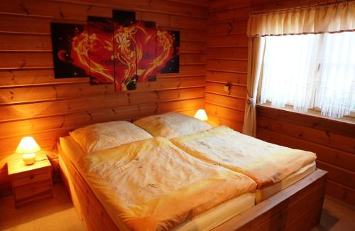 ein Schlafzimmer mit einem Bett in einer Holzwand in der Unterkunft Ferienhaus Hohenlubast in Gräfenhainichen