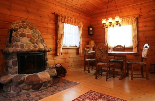 a living room with a fireplace in a log cabin at Ferienhaus Hohenlubast in Gräfenhainichen