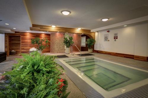 a large swimming pool in a lobby with plants at Queens Landing in Niagara-on-the-Lake