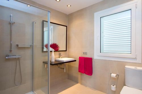 a bathroom with a shower and a sink and a mirror at Coral Villas in Puerto del Carmen