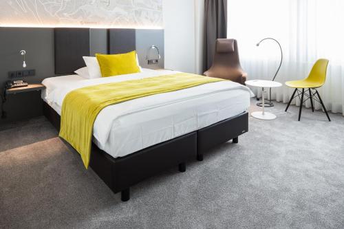 a bedroom with a large bed with a yellow blanket at FischerS in Kassel