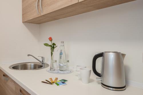 a kitchen counter with a coffee pot and a sink at Hotel City Green Berlin in Berlin