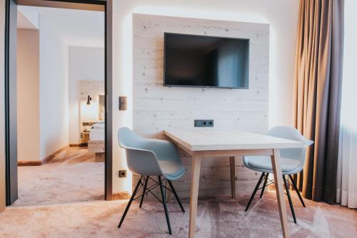 a dining room with a table and two chairs and a television at FischerS in Kassel