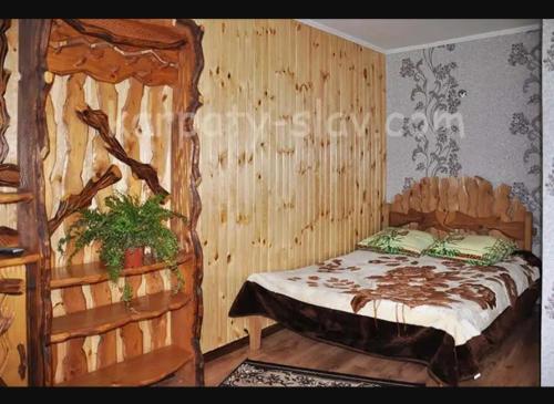 a bedroom with a bed in a wooden wall at "Різьб'ярська садиба" in Slavske