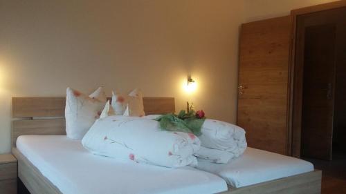 a bed with white sheets and pillows in a bedroom at Apart Söllbacherhof in Fügen