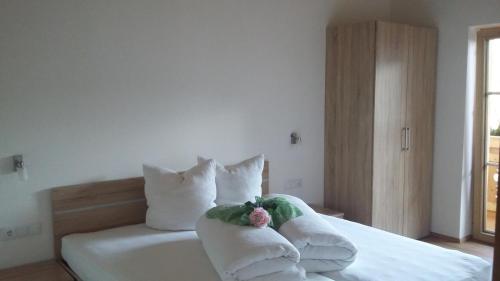 a bedroom with a bed with white sheets and pillows at Apart Söllbacherhof in Fügen
