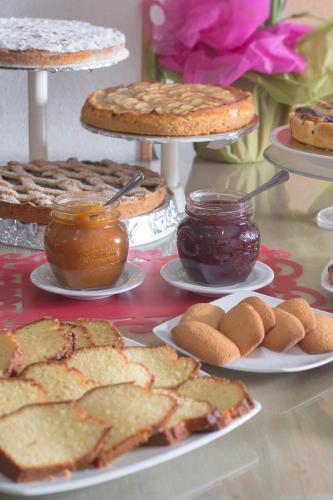 a table topped with plates of food and jams and pies at Hotel Bixio in Lido di Camaiore