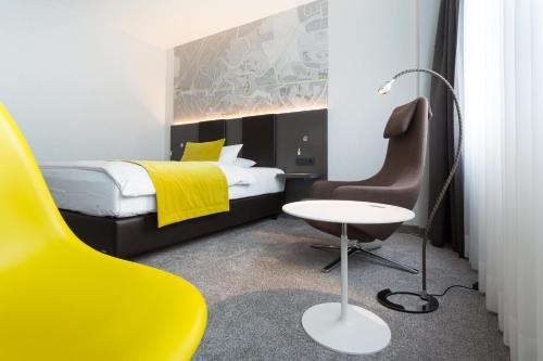 1 dormitorio con cama, escritorio y silla en FischerS - Kurparkhotel Bad Wilhelmshöhe en Kassel