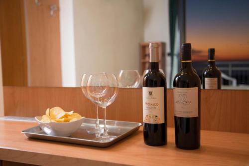 a table with two bottles of wine and a plate of chips at Hotel Bixio in Lido di Camaiore