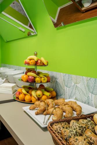 a table topped with plates of fruit and bread at Hotel City Green Berlin in Berlin