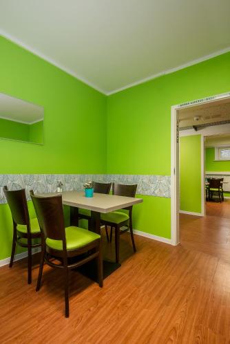 a dining room with green walls and a table and chairs at Hotel City Green Berlin in Berlin