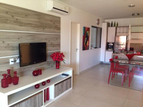 a living room with a flat screen tv on a wooden wall at HOTEL CANARIUS DE GRAVATA - Flat in Gravatá